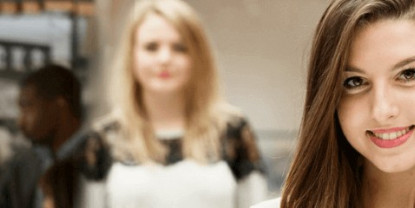 Étudiante souriante au premier plan dans un environnement académique NEOMA